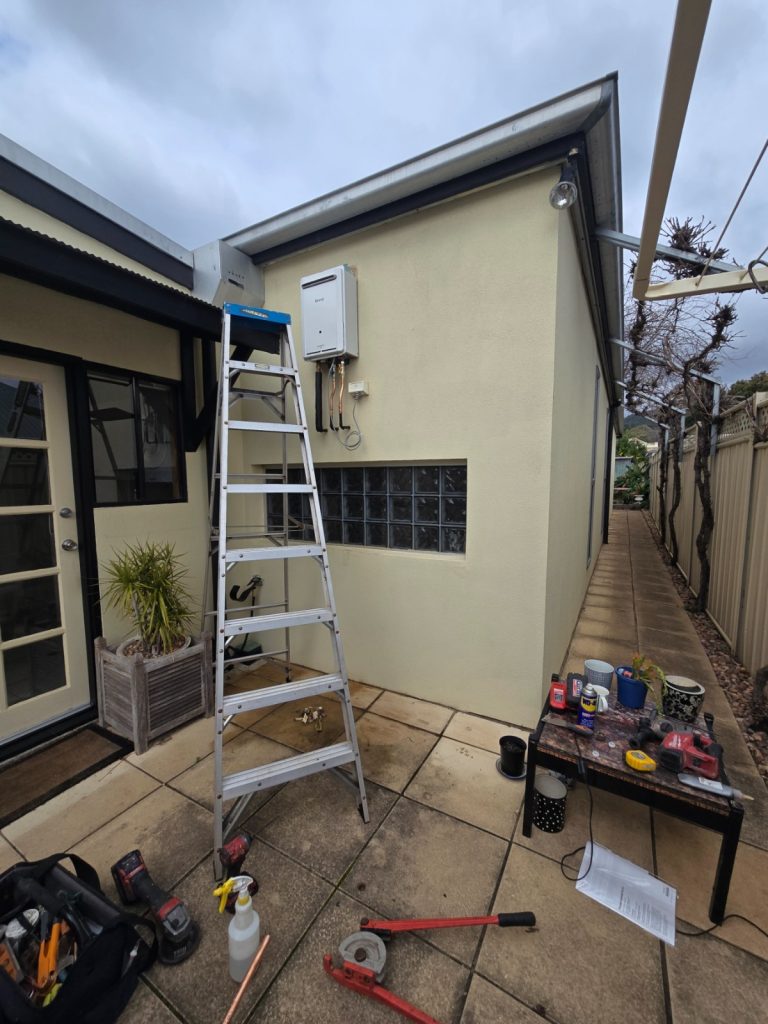 Ladder and tools set up beside an old Rinnai hot water unit during a replacement job in Mitcham, Adelaide